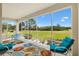 Enclosed patio with vibrant furniture overlooking lush green golf course at 8779 Se 141St Lane Rd, Summerfield, FL 34491