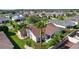 A home with a brown roof surrounded by lush landscaping and neighboring houses at 898 Abaco Path, The Villages, FL 32163