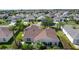 A home with a brown roof surrounded by lush landscaping and neighboring houses at 898 Abaco Path, The Villages, FL 32163