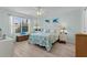 Bright bedroom featuring coastal decor, a large window, and wood-look flooring at 898 Abaco Path, The Villages, FL 32163