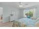 Serene bedroom featuring wood-look floors, a bright window, and a coastal theme at 898 Abaco Path, The Villages, FL 32163