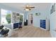 Bright bedroom with two windows, blue walls, modern ceiling fan, and space for crafts and hobbies at 898 Abaco Path, The Villages, FL 32163
