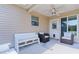 Covered patio with ceiling fan, bench seating, and comfortable chairs, offering relaxation and backyard views at 898 Abaco Path, The Villages, FL 32163
