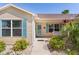 Inviting front porch with swing, blue shutters and a beautifully landscaped walkway at 898 Abaco Path, The Villages, FL 32163