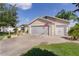 Attached two-car garage with well-maintained lawn, landscaping, and inviting curb appeal at 898 Abaco Path, The Villages, FL 32163