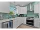 Updated kitchen features stainless appliances, white cabinets, and a backsplash at 898 Abaco Path, The Villages, FL 32163