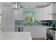 Updated kitchen features stainless appliances, white cabinets, and a backsplash at 898 Abaco Path, The Villages, FL 32163