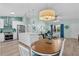 Open concept kitchen and dining area with island, stainless appliances, and pendant lighting at 898 Abaco Path, The Villages, FL 32163