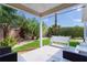 Covered patio with ample shade, bench seating, privacy landscaping, and well manicured lawn at 898 Abaco Path, The Villages, FL 32163