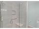 Modern shower with glass enclosure, tile surround, built-in shelves and a convenient shower seat at 898 Abaco Path, The Villages, FL 32163