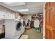 Functional basement laundry room with a washer and dryer, storage shelves, and work area at 9023 Silver Lake Dr, Leesburg, FL 34788