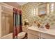 Retro bathroom with a floral-patterned wallpaper, vanity, and shower-tub combo at 9023 Silver Lake Dr, Leesburg, FL 34788