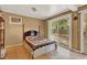 Cozy bedroom featuring hardwood floors, paneled walls, and sliding glass doors to the backyard at 9023 Silver Lake Dr, Leesburg, FL 34788