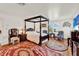 Bedroom with a four-poster bed, vintage rug, and decorative furnishings at 9023 Silver Lake Dr, Leesburg, FL 34788