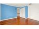 Bedroom featuring hardwood floors and a closet, with a blue accent wall for a pop of color at 9023 Silver Lake Dr, Leesburg, FL 34788