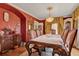 Elegant dining room with red accent wall, hardwood floors, and a decorative chandelier at 9023 Silver Lake Dr, Leesburg, FL 34788
