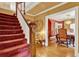 Elegant foyer with a carpeted staircase, hardwood floors, and views of the dining room at 9023 Silver Lake Dr, Leesburg, FL 34788