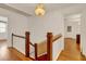Hallway with hardwood floors, a staircase, and a decorative chandelier at 9023 Silver Lake Dr, Leesburg, FL 34788