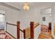 Upstairs hallway featuring wood railing and chandelier at 9023 Silver Lake Dr, Leesburg, FL 34788