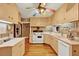 Retro kitchen with light wood cabinets, a colorful ceiling fan, and a stainless steel refrigerator at 9023 Silver Lake Dr, Leesburg, FL 34788