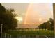 Vibrant rainbow over the lake, visible from landscaped yard of the property, offering a scenic and unique view at 9023 Silver Lake Dr, Leesburg, FL 34788