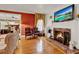 Cozy living room with a fireplace, leather chairs, hardwood floors, and a view into the adjacent office at 9023 Silver Lake Dr, Leesburg, FL 34788