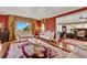 Sophisticated living room with rich red walls, hardwood floors, and a glimpse of the water through large windows at 9023 Silver Lake Dr, Leesburg, FL 34788
