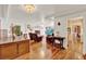 Bright living room featuring a white fireplace, hardwood floors, and access to the kitchen at 9023 Silver Lake Dr, Leesburg, FL 34788