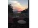 Enjoy a stunning sunset view from the outdoor patio with decorative railing overlooking the lake at 9023 Silver Lake Dr, Leesburg, FL 34788