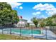 Enclosed pool with clear water next to the estate, with a lake view, surrounded by lush greenery at 9023 Silver Lake Dr, Leesburg, FL 34788