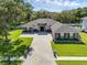 Expansive single-story home with large driveway, lush landscaping, and stone and siding exterior at 9518 Mid Summer Ln, Leesburg, FL 34788