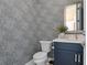 Stylish powder room featuring a patterned wallpaper, a modern sink, and a matching mirror at 9518 Mid Summer Ln, Leesburg, FL 34788