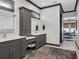 Bathroom boasts dual vanities, gray cabinets, and a view into the bedroom at 9518 Mid Summer Ln, Leesburg, FL 34788