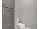 A well lit bathroom with a white toilet and a stylish gray vanity for storage at 9518 Mid Summer Ln, Leesburg, FL 34788