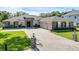 Well-manicured lawn and cobblestone driveway lead to a stone-accented home with a two-car garage at 9518 Mid Summer Ln, Leesburg, FL 34788