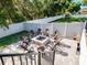 Charming backyard fire pit area with stone pavers, seating, play set and white vinyl fence at 9518 Mid Summer Ln, Leesburg, FL 34788