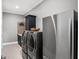 A bright laundry room with modern appliances, a counter, and shelving for storage at 9518 Mid Summer Ln, Leesburg, FL 34788