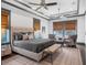 A spacious main bedroom retreat featuring a tray ceiling, plush bed, and windows at 9518 Mid Summer Ln, Leesburg, FL 34788