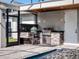 A stylish outdoor kitchen by the pool features modern appliances and a stone surround on the counter and cabinets at 9518 Mid Summer Ln, Leesburg, FL 34788