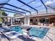 Inviting pool area features a screened-in enclosure, in-pool loungers, outdoor kitchen, and comfortable seating area at 9518 Mid Summer Ln, Leesburg, FL 34788