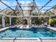 A screened pool area has lounge chairs sitting in the pool and a covered area with seating on the other end at 9518 Mid Summer Ln, Leesburg, FL 34788