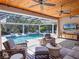 Relaxing screened pool area with ceiling fans, comfortable seating, and a view of the beautiful landscaped backyard at 9518 Mid Summer Ln, Leesburg, FL 34788