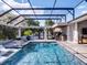 Beautiful screened pool area with spa, outdoor kitchen, in-pool loungers, and comfortable seating for entertaining at 9518 Mid Summer Ln, Leesburg, FL 34788