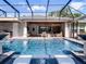 Sparkling pool with spa features, screened enclosure, outdoor kitchen, and lounge area for relaxing and entertaining at 9518 Mid Summer Ln, Leesburg, FL 34788