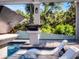 Modern pool area featuring in-pool loungers and a clear view of lush landscaping and the surrounding greenery at 9518 Mid Summer Ln, Leesburg, FL 34788