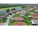Aerial view of a neighborhood with a lake, and golf course in the distance at 453 Treviso Dr, Poinciana, FL 34759