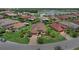 Aerial view of a home in a residential community with manicured lawns and a lake nearby at 453 Treviso Dr, Poinciana, FL 34759