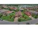 Aerial view of a home in a residential community with manicured lawns and a lake nearby at 453 Treviso Dr, Poinciana, FL 34759