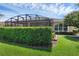Landscaped backyard featuring a privacy hedge and manicured lawn at 453 Treviso Dr, Poinciana, FL 34759