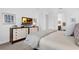 Bedroom featuring a dresser with a TV and neutral decor with a view into the bathroom at 453 Treviso Dr, Poinciana, FL 34759